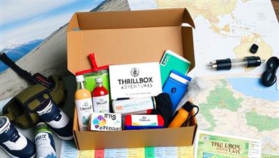 An assortment of adventure gear and travel essentials neatly packed in a subscription box, surrounded by outdoor scenery and maps, hinting at the excitement and exploration awaiting subscribers of ThrillBox Adventures.