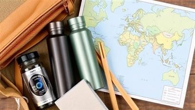 An eco-friendly travel kit with reusable water bottles, bamboo utensils, and a map of sustainable destinations, symbolizing the eco-conscious approach of GreenRoutes Travel.
