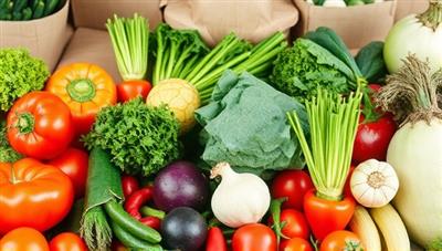 A vibrant image of fresh organic vegetables arranged in a colorful and appealing way, with eco-friendly packaging materials in the background, symbolizing sustainability and freshness.