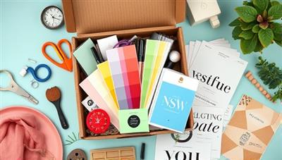 An aesthetically pleasing flat lay of a subscription box filled with design tools, color swatches, typography samples, and inspirational mood boards, creating a visual feast for creative minds.