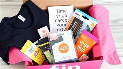 A beautifully designed subscription box overflowing with fitness goodies, including workout apparel, protein bars, yoga accessories, and a motivational quote card, creating an enticing and visually appealing package for FitBox Delight subscribers.