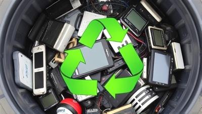 A collection of old electronic devices and gadgets piled up in a recycling bin, with green recycling symbols and arrows indicating the eco-friendly tech disposal process of EcoTech Renew, highlighting the sustainability and environmental impact of the tech recycling and upcycling service.