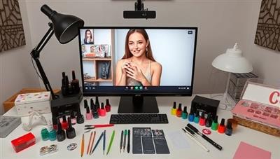 A virtual nail art studio setup featuring a nail artist demonstrating designs on a model via video call, surrounded by a selection of nail polish colors, art tools, and curated nail art kits, creating an inspiring and creative space for nail art enthusiasts to explore and create beautiful designs.