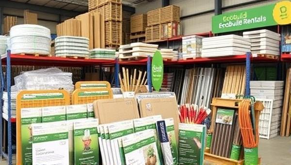 An eye-catching display of various sustainable construction materials and tools available for rental, arranged neatly in a warehouse setting with eco-friendly labels and signage, conveying the message of resource conservation and environmental responsibility at EcoBuild Rentals.