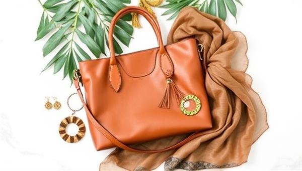 An elegant flat lay displaying a selection of eco-friendly fashion accessories from EcoChic Essentials, including a recycled leather handbag, upcycled jewelry pieces, and a sustainable silk scarf, arranged against a backdrop of green leaves and natural textures, embodying style and sustainability.